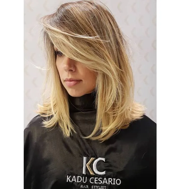 Mulher de pele clara com cabelo chanel longo de lado loiro