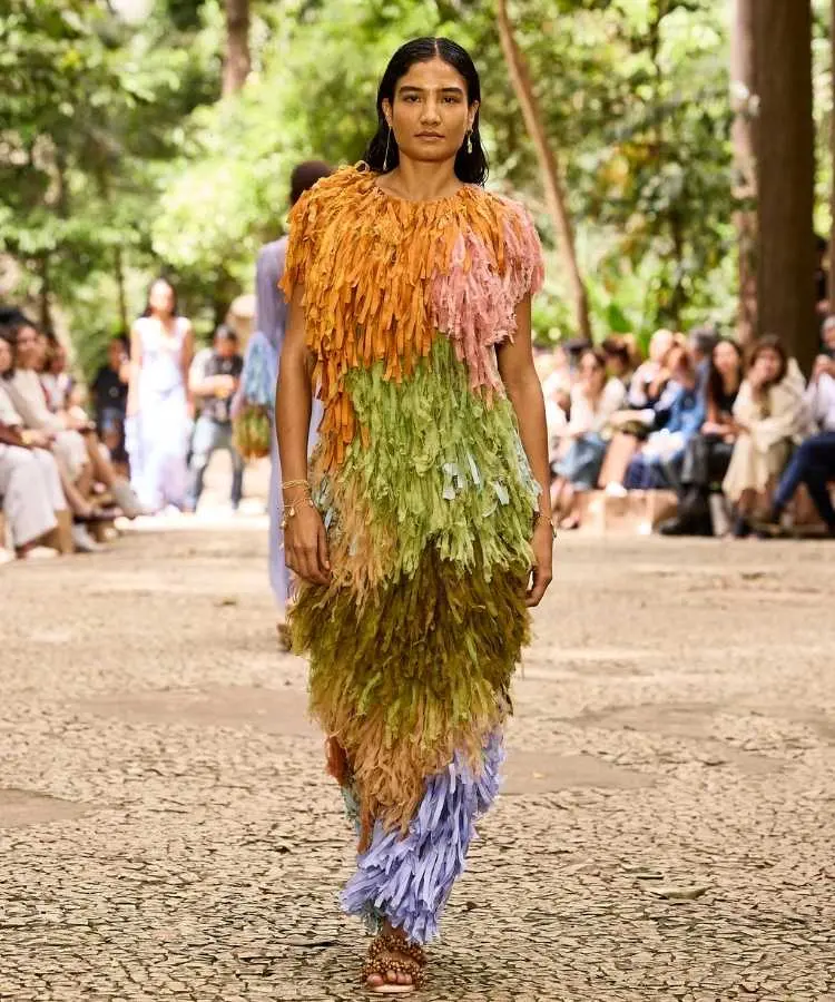 Foto de modelo na passarela usando vestido de franjas coloridas