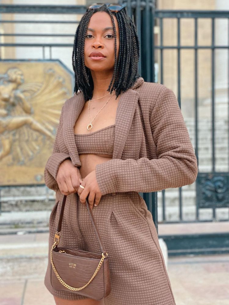 mulher usando conjunto de top, short e blazer cropped marrom com bolsa baguete da mesma cor
