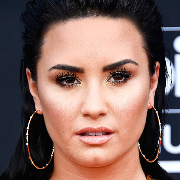 Em uma foto fechada, Demi Lovato exibe sua boa maquiagem e brincos de argolas grandes Demi Lovato - famosos do signo de leão