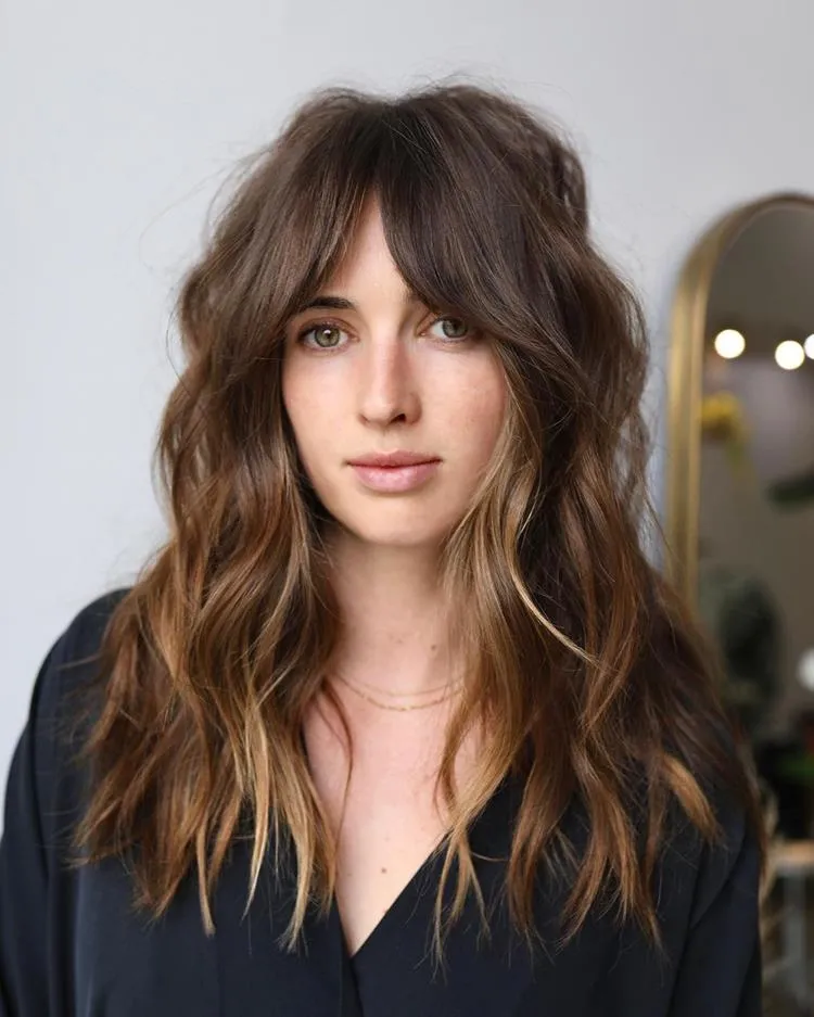 mulher com cabelo longo castanho e franja média