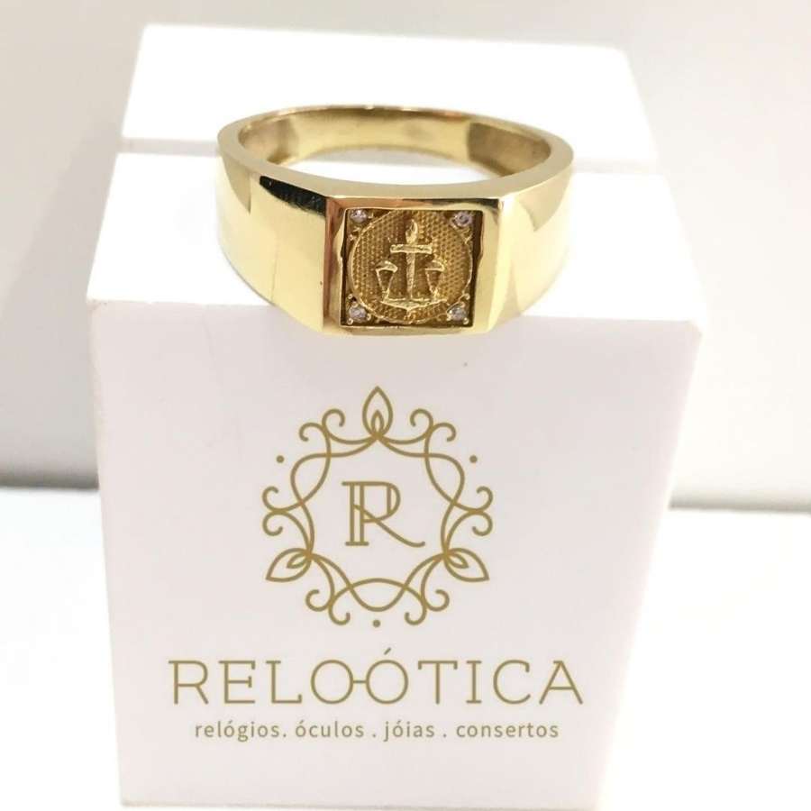 Anel de formatura dourado com símbolo de direito