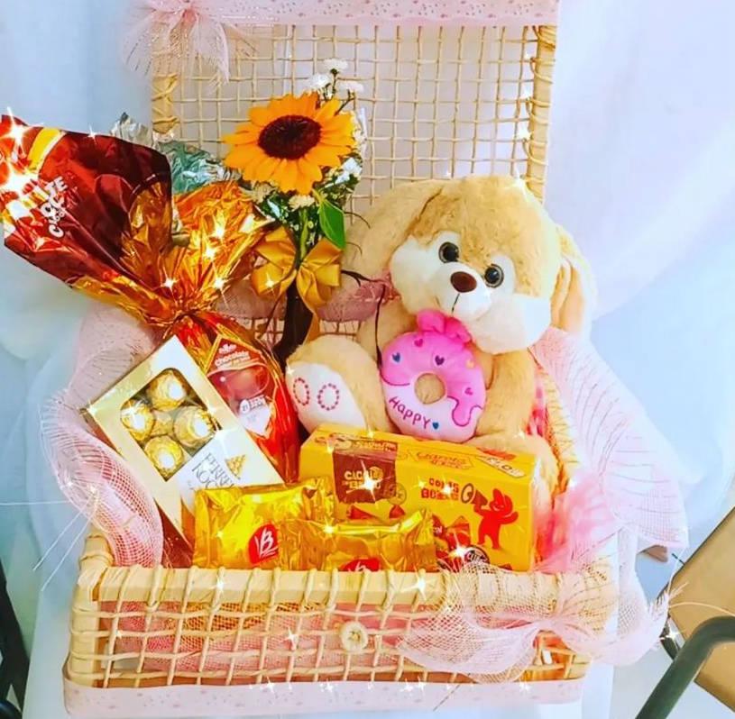 Cesta de Páscoa com urso de pelúcia,, flores, ovo e doces 
