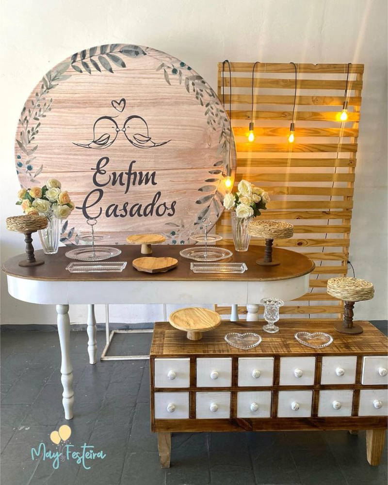 Painel escrito "enfim casados" com pombinhos se beijando.