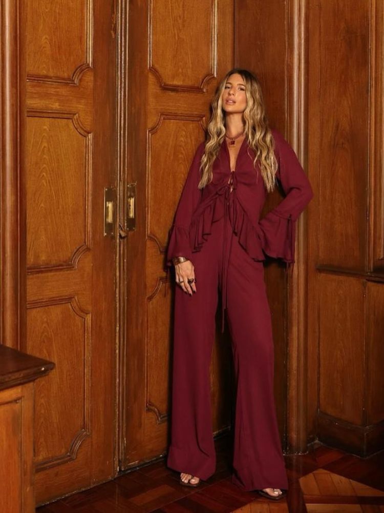 Mulher de pele clara usando  camisa com babados e calça pantalona em marsala 