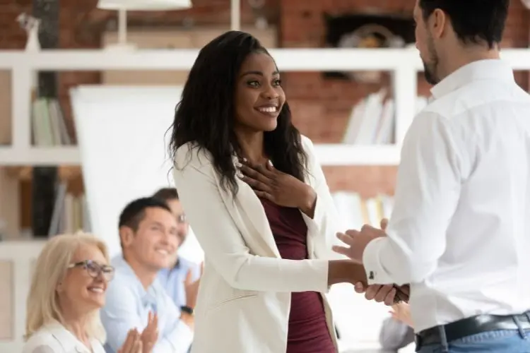 Mulher recebendo uma conquista individual por no trabalho