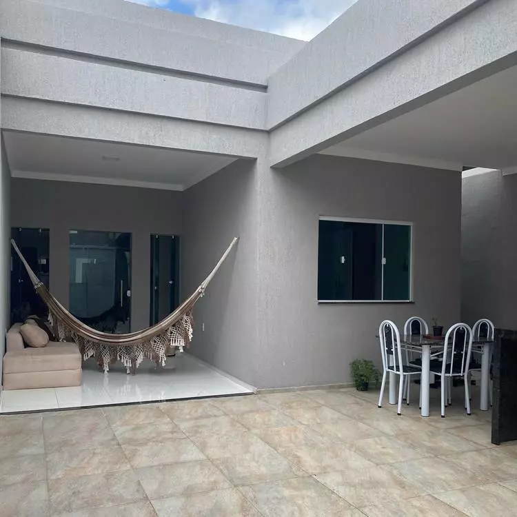 Entrada de casa moderna por dentro. Mesa de 4 cadeiras, rede marrom e branca e sofá