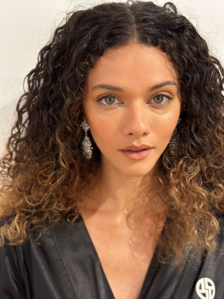 Mulher de pele clara e cabelo cacheado usando maquiagem natural