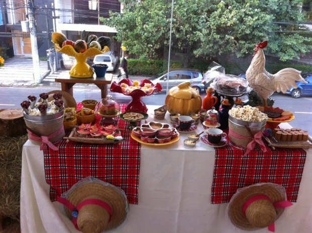 Mesa decorando vitrine, com comidas típicas de são joão