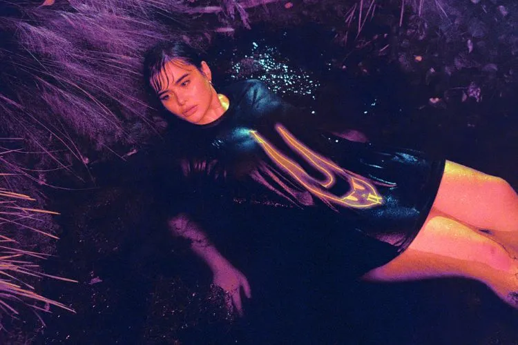 Barbie Ferreira deitada com uma camisa preta com estampa de coelho
