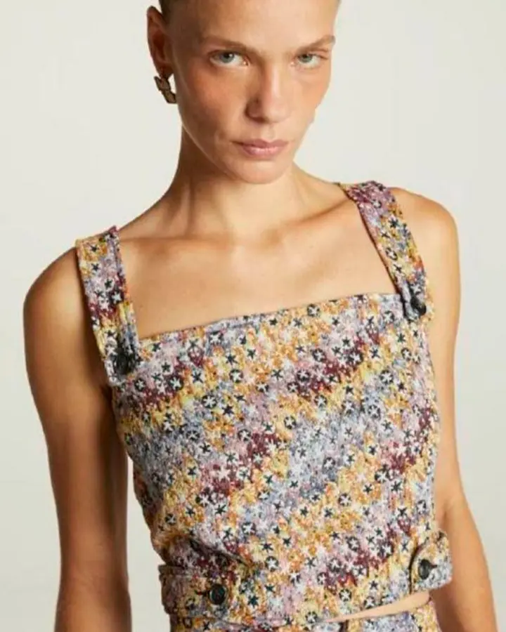 Modelo usando uma blusa colorida.
