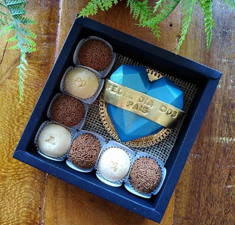 Uma cesta simples contendo docinhos, acompanhada de uma coração de chocolate para o Dia dos Pais.