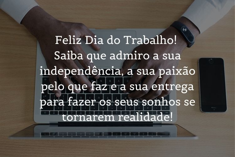Foto de homem de pele negra mexendo no computador e frase "Feliz Dia do Trabalho! Saiba que admiro a sua independência, a sua paixão pelo que faz e a sua entrega para fazer os seus sonhos se tornarem realidade!"