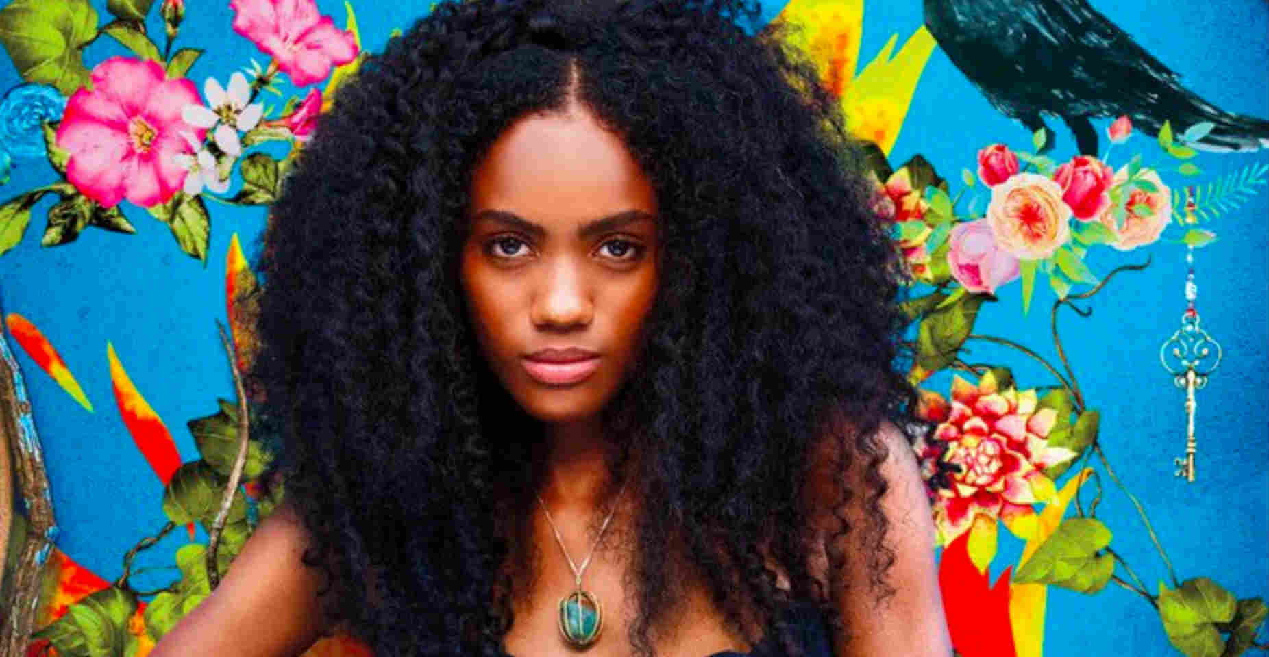 Capa da série colombiana Sempre Bruxa Carmen Eguiluz, personagem da série Sempre Bruxa, posando em frente a uma parede azul com estampa de flores tropicais