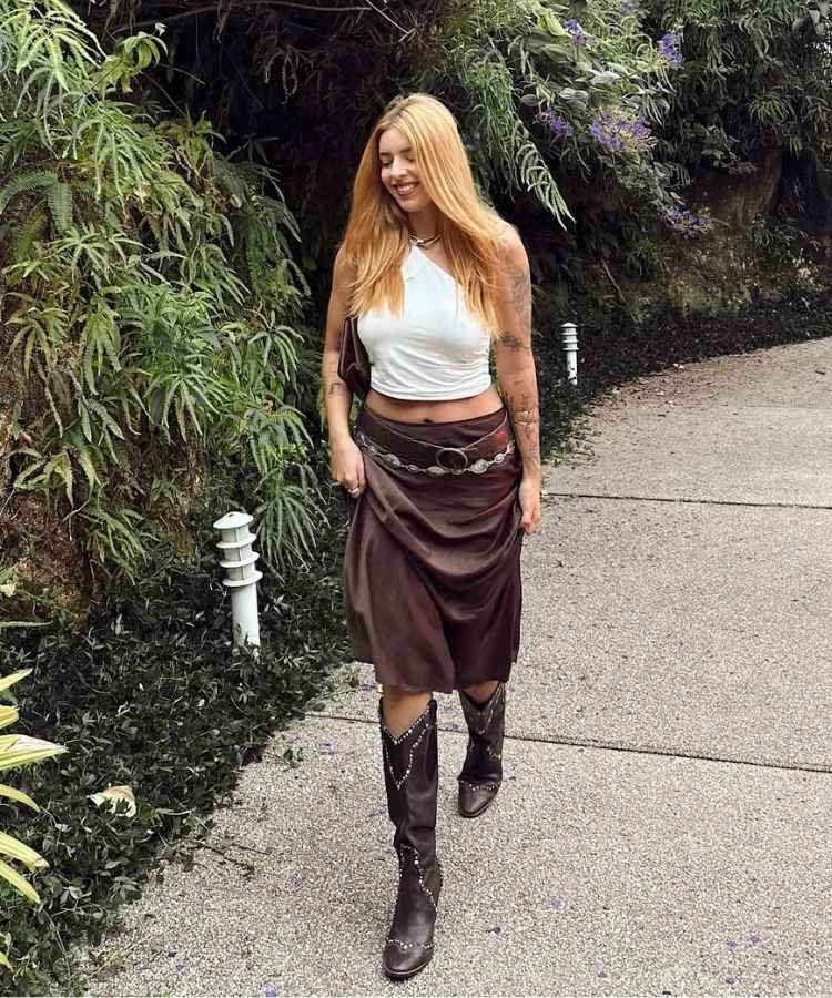 Foto de Juliana Coutto, um dos influencers veganos, usando cropped branco, saia marrom e botas de cowboy