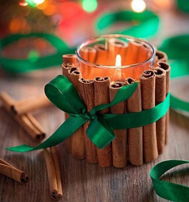 Foto de mesa com velas envoltas de canela em pau com laço verde
