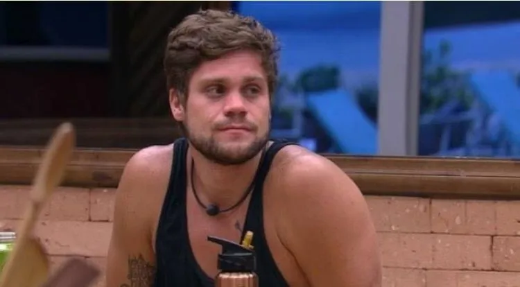 Breno Simões sentado usando regata preta 