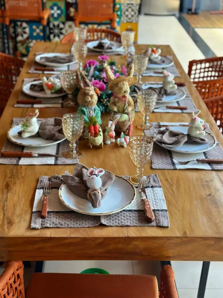 Mesa de madeira posta com coelhos de centro de mesa