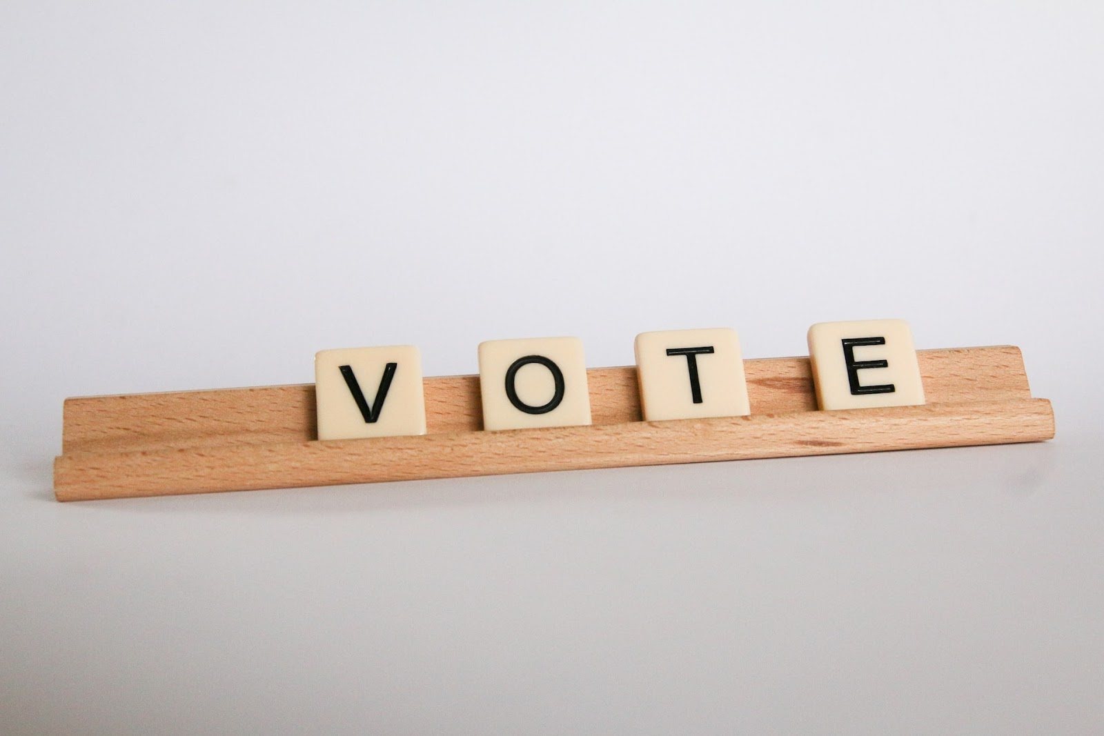 Suporte de maneira com pequenos quadrados cada um com uma letra. A palavra formada é VOTE