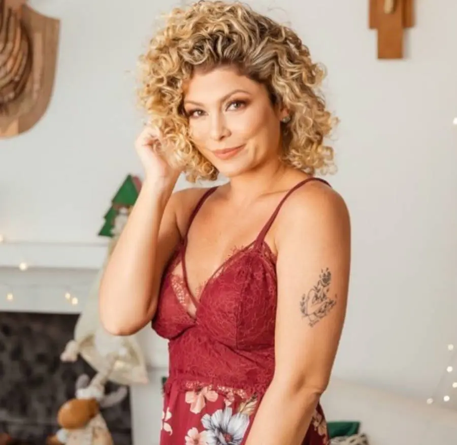 Foto de Barbara Borges de lado mostrando sua tatuagem no braço