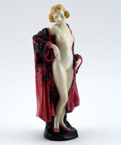 A imagem mostra uma escultura de uma mulher em pé, parcialmente coberta por um robe vermelho. O robe está aberto, revelando seu corpo nu. Ela está com uma mão na cintura e a outra apoiada no robe. A expressão corporal transmite confiança e a pose é relaxada. A escultura parece ser feita com detalhes delicados, com a cor de pele clara e cabelos loiros da figura contrastando com o robe vermelho escuro com detalhes em preto. Ela também está usando sapatos vermelhos, o que complementa o tom do robe.
