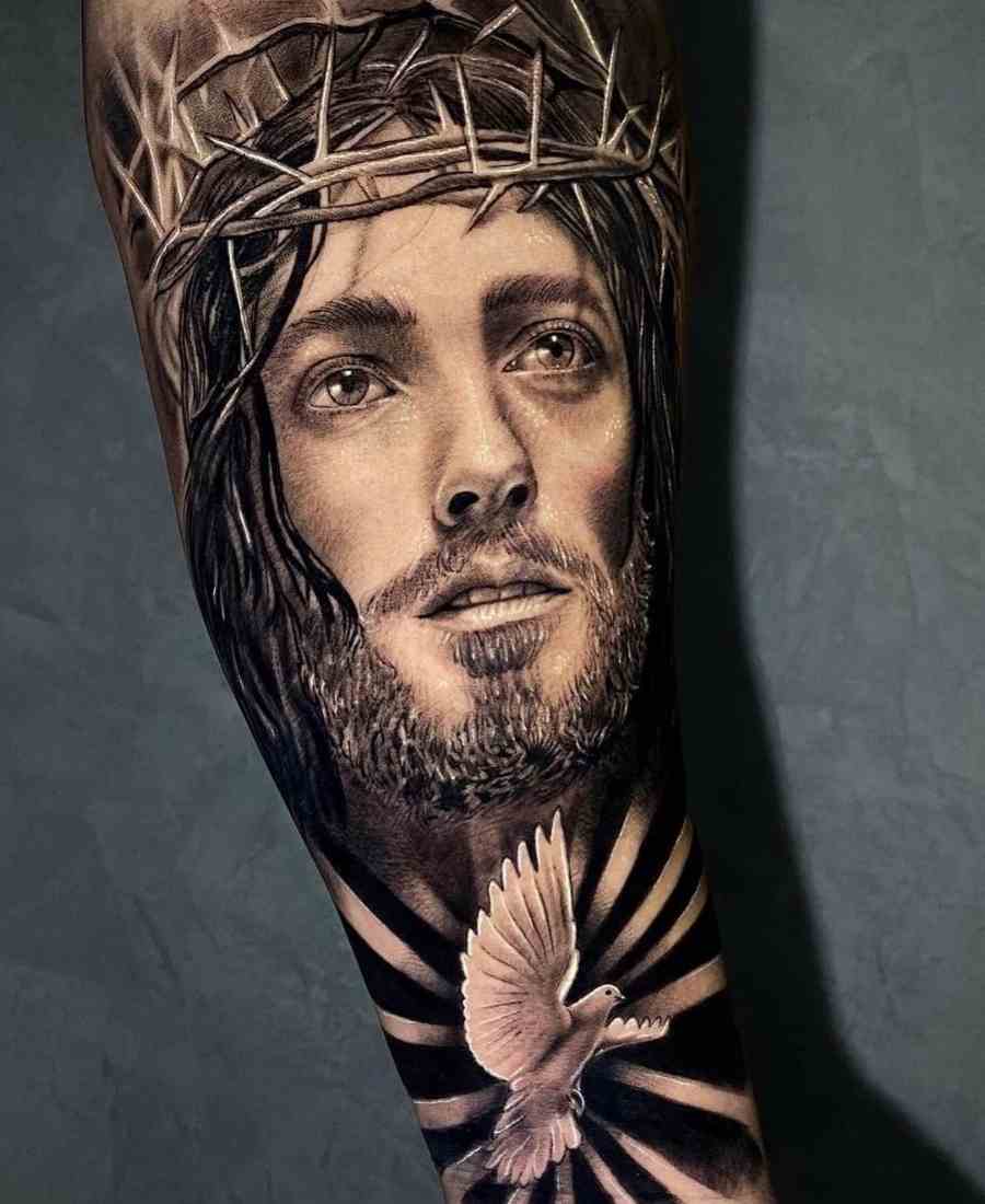 Foto de tatuagem religiosa realista com rosto de Jesus Cristo.