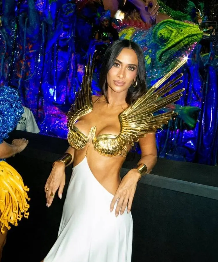 Silvia Braz usando vestido branco com top de asas douradas