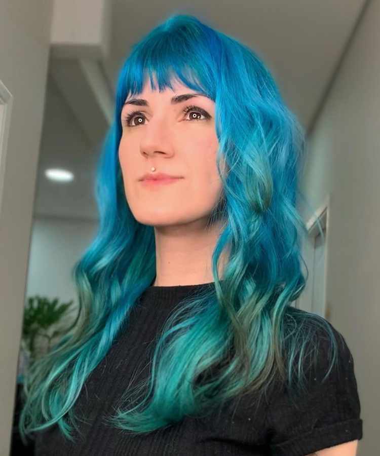 Corte de cabelo longo azul com camadas e franja curta.