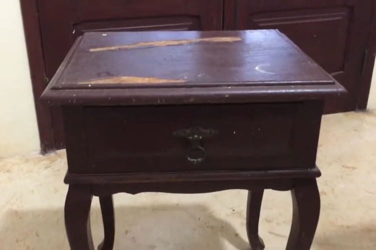 Mesa de cabeceira de madeira antiga com lascados 
