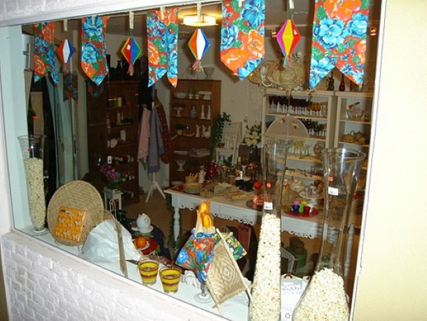 Vitrines de festa junina, com pipoca e bandeirinhas de chita