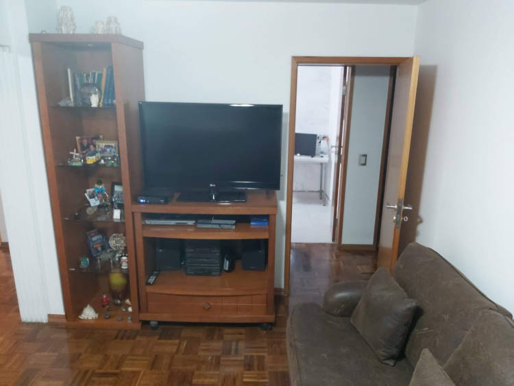Antiga sala com rack marrom escuro e tv.