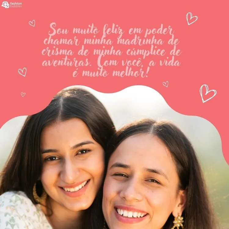 Foto de duas mulheres de pele clara e cabelo preto próximas com fundo rosa de coração. Acima há a frase "Sou muito feliz em poder chamar minha madrinha de crisma de minha cúmplice de aventuras. Com você, a vida é muito melhor!"