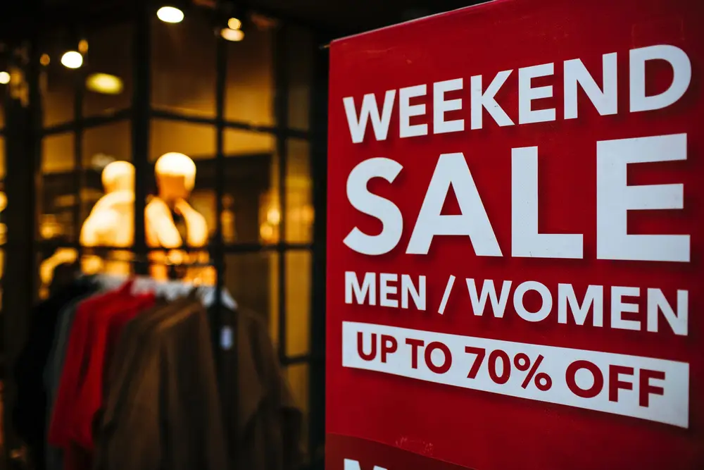 Placa vermelha com aviso de promoção em inglês em loja de roupas