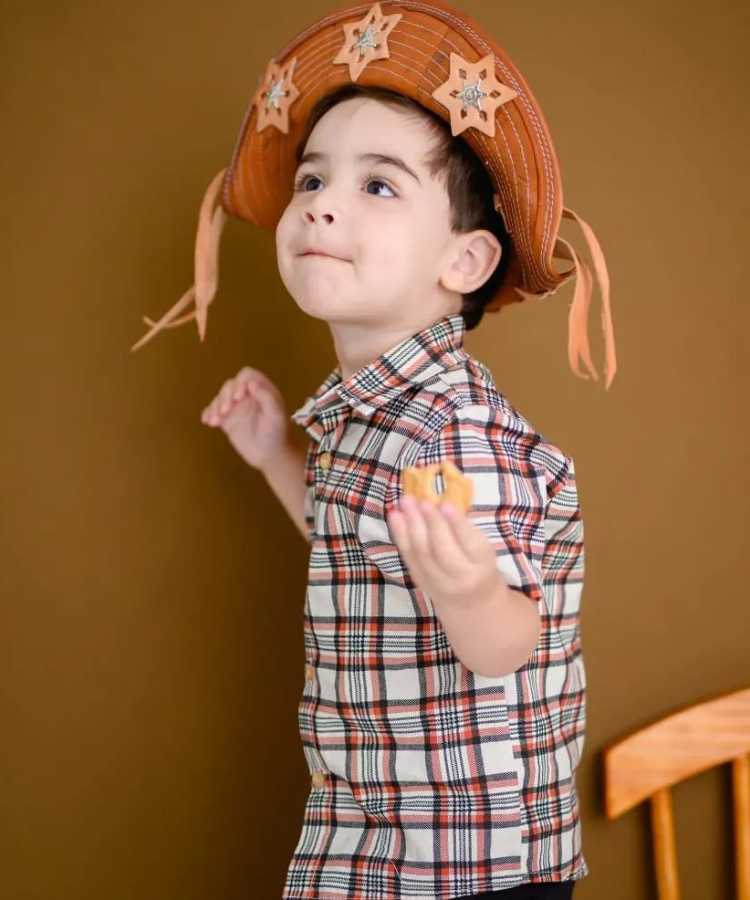 Menino com camisa xadrez e chapéu de cangaceiro