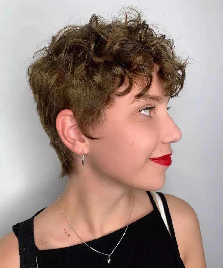Corte pixie mulher com cabelo loiro escuro ondulado