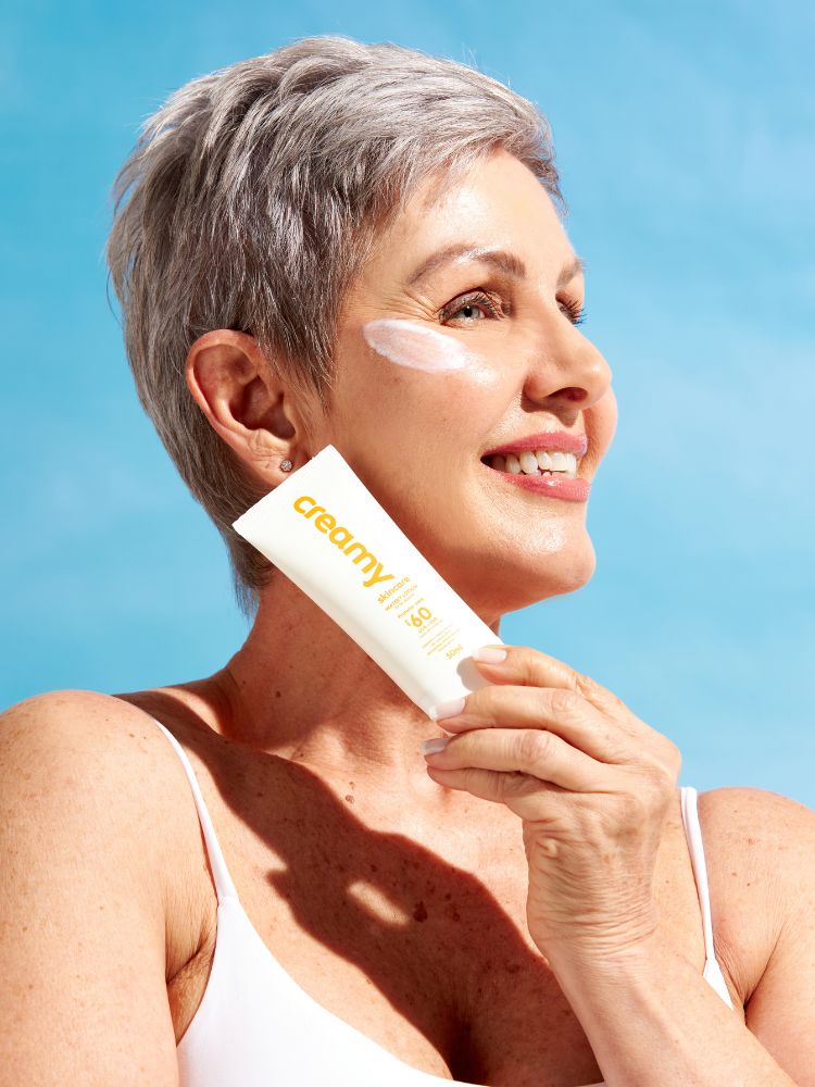 mulher utilizando o lançamento da creamy, o protetor solar. 