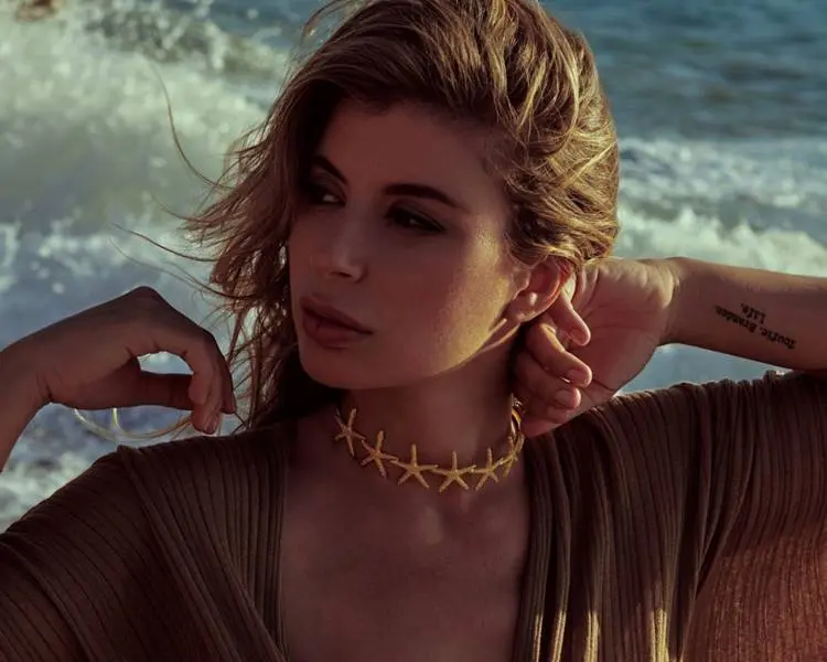 Foto de modelo com joia na praia.