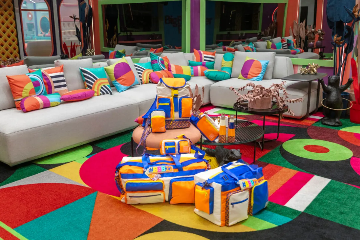 Bolsas e mochilas coloridas da lojinha do Big Brother Brasil expostas na sala da casa do BBB