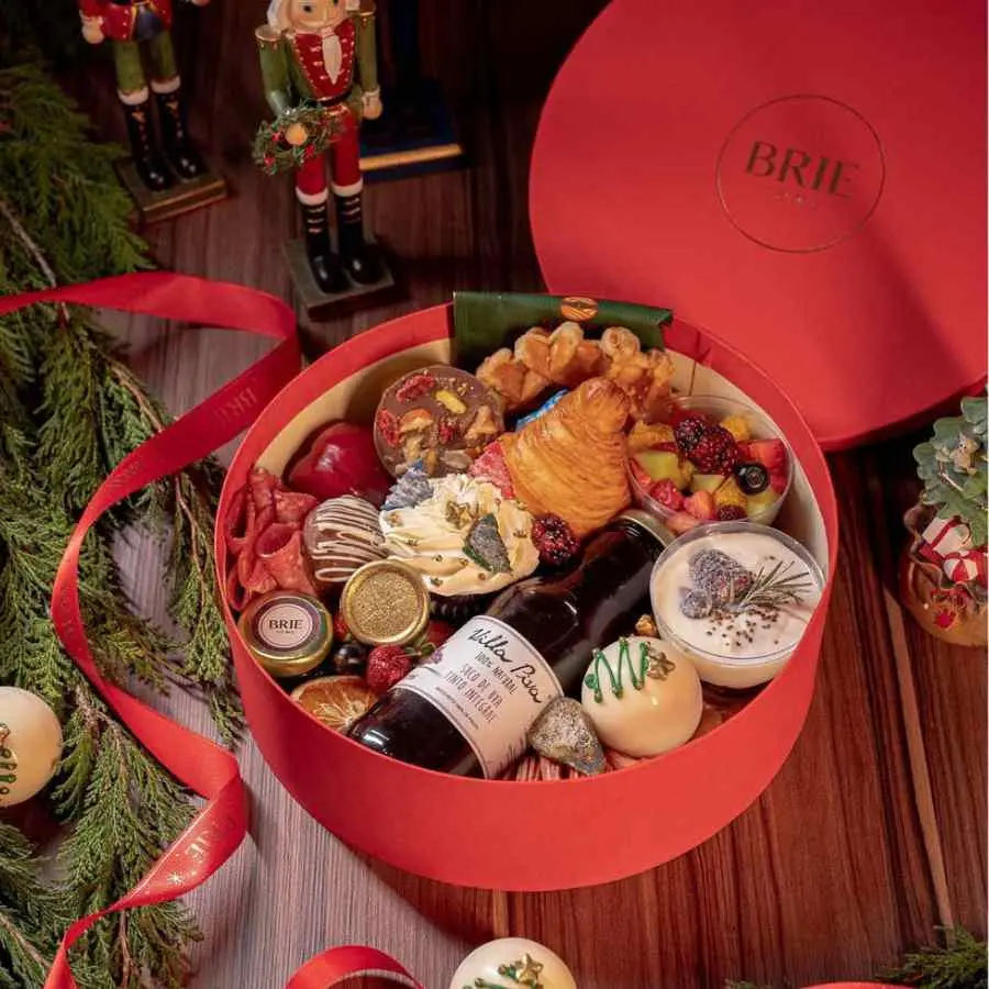 Foto de café da manhã de para 25 de dezembro com suco de uva, doces, pães, frutas e geleias.