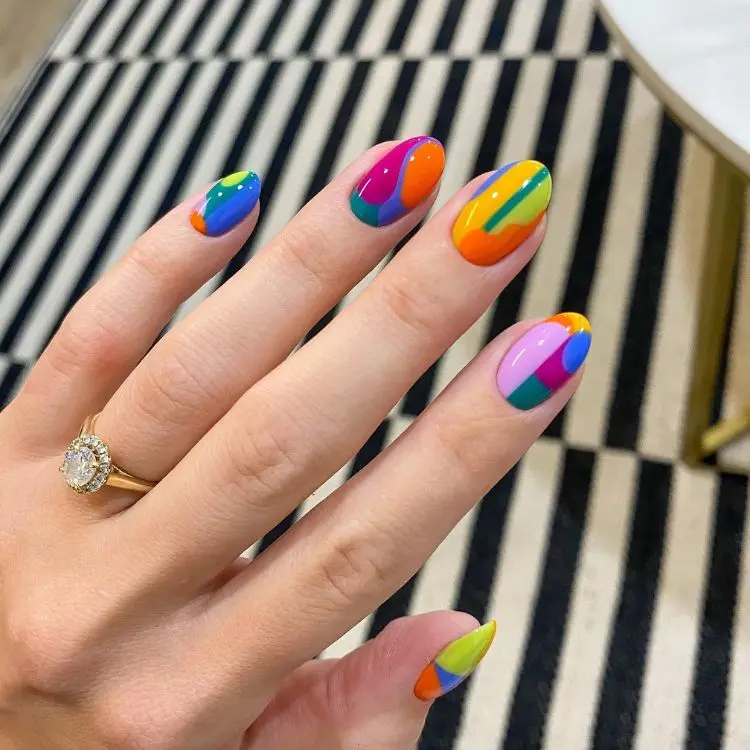 Unhas redondas com nail art abstrata em cores do arco-íris