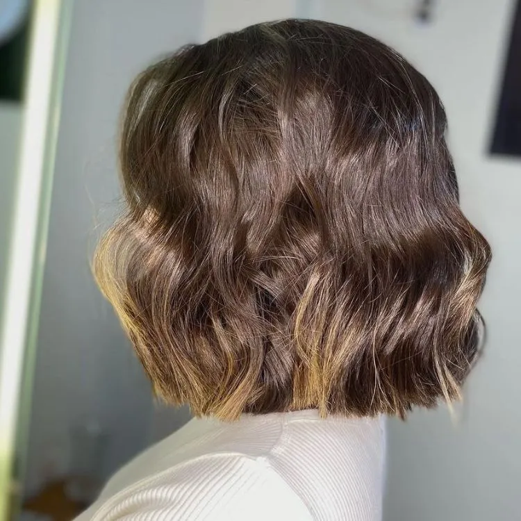 Mulher de pele clara de lado com cabelo chanel