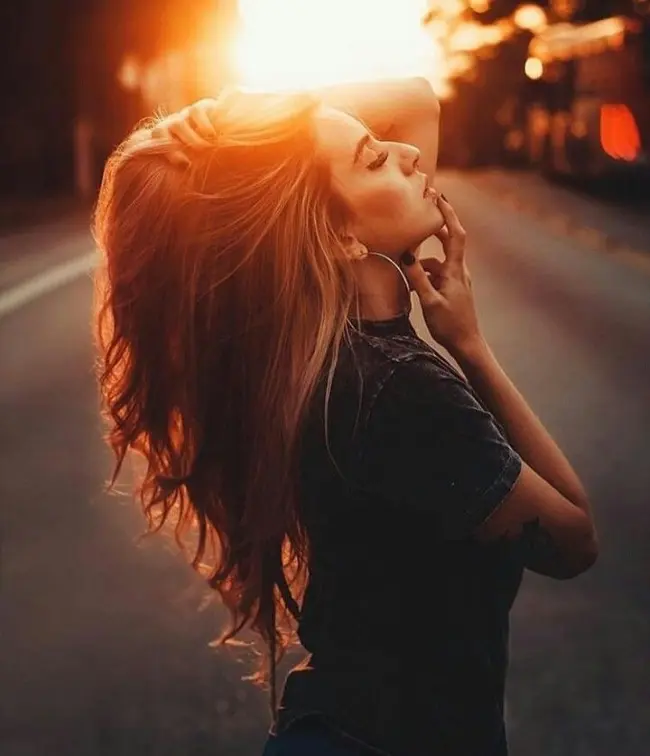 Frase para foto pensativa mulher loira veste t-shirt cinza e usa argola Frase para foto pensativa