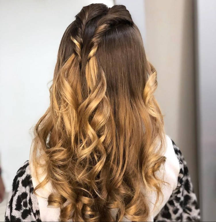 Mulher de pele clara com cabelo meio preso com dois enrolados na cabeça