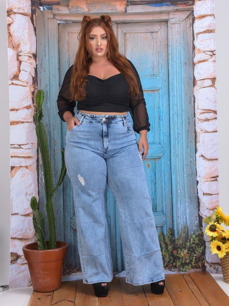 Mulher de pele clara com cropped preto calça jeans wide leg
