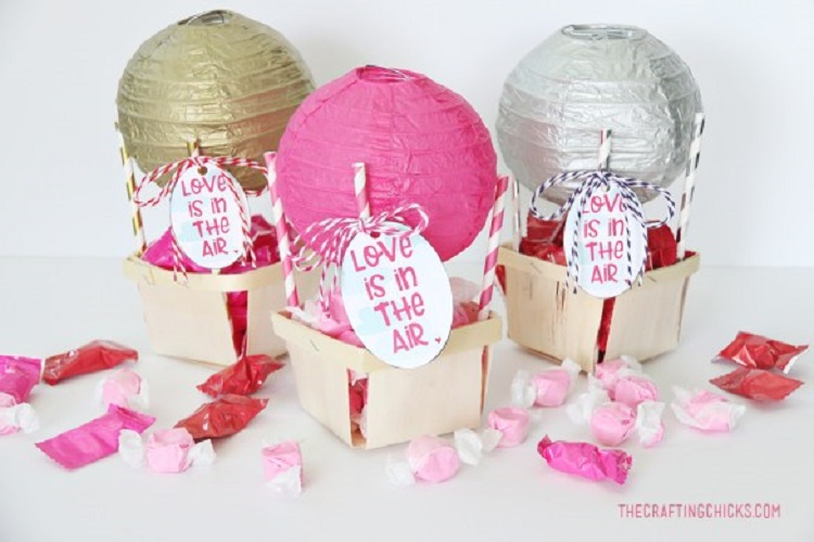 Cestas com balão em cima e escrito "love is in the air"