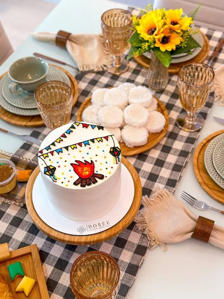 Mesa posta com toalha xadrez e bolo dcorado estilo bento cake 