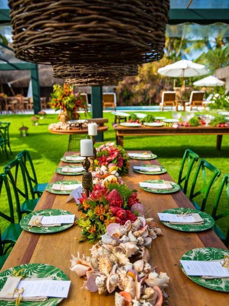 Centro de mesa de casamento com flores e conchas.