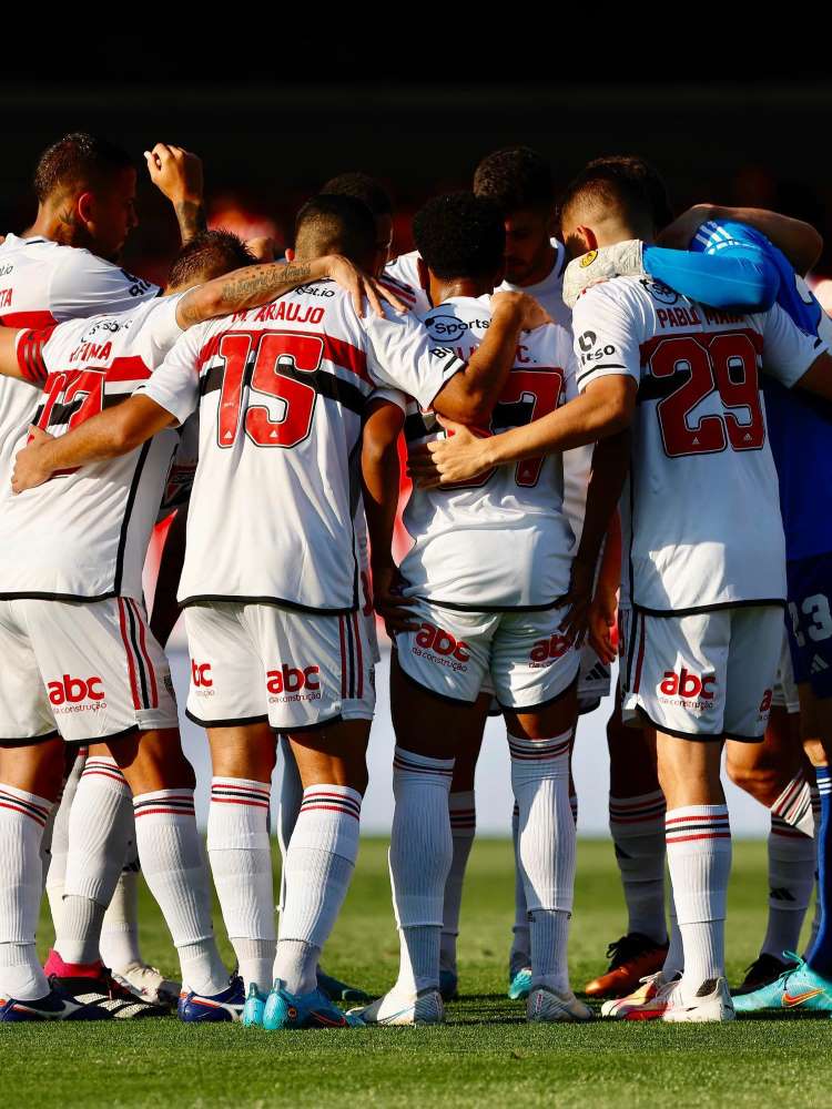 Elenco do São Paulo se abraçando e usando o primeiro uniforme. 