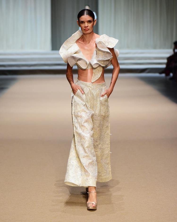 modelo com conjunto de top e calça brancos.