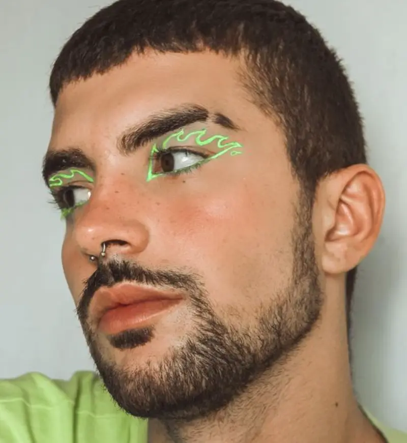 Homem de pele clara com delineado de fogo em verde neon